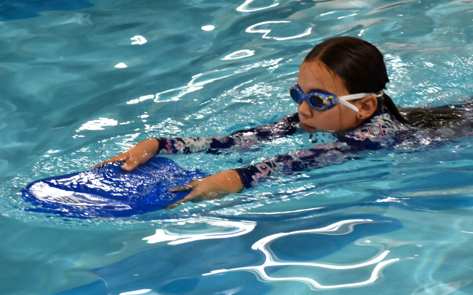 Intermediate Advanced girl with goggles and kickboard