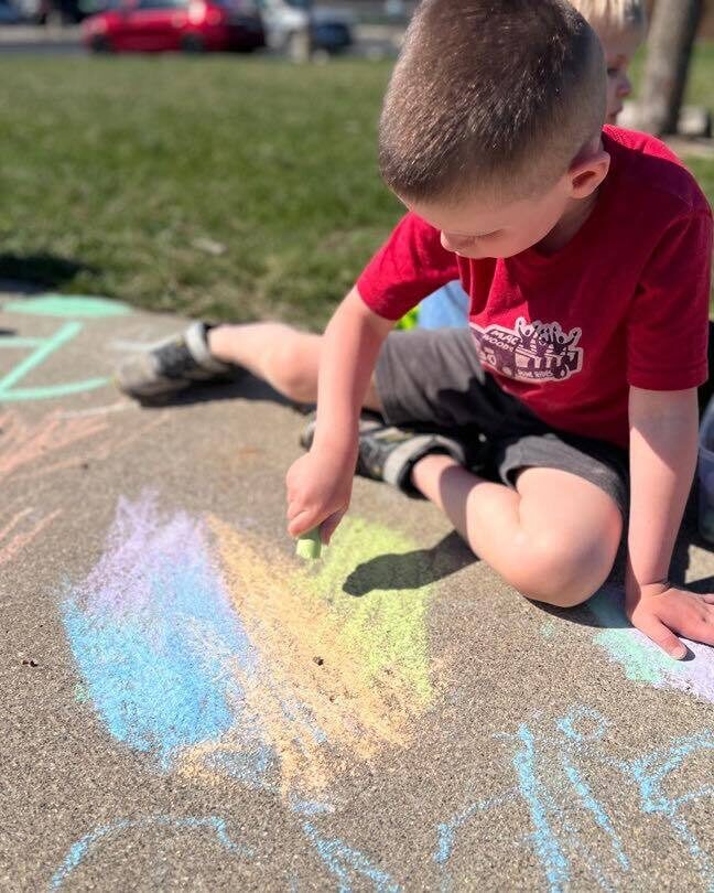 Boy drawing on sidewalk with chalk