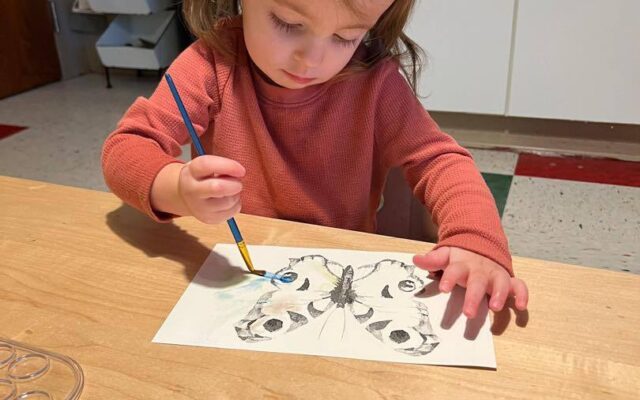 Toddler girl painting watercolor butterfly