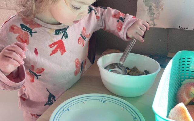 Toddler girl serving herself food