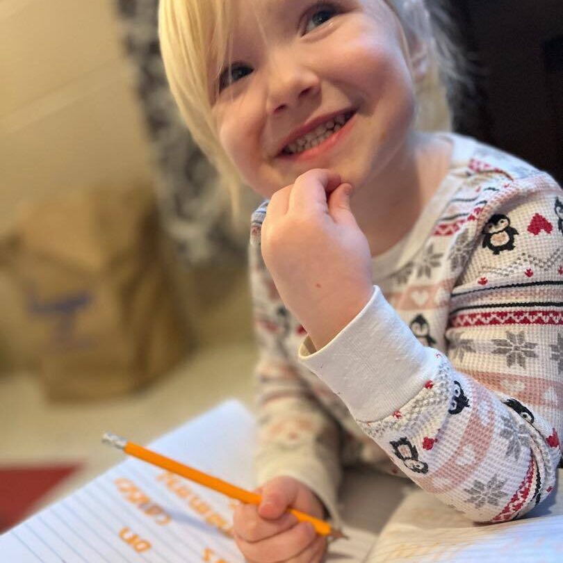 Preschool girl writing in her journal and smiling